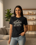 Woman wearing a black t-shirt with a mountain design and text in a living room.