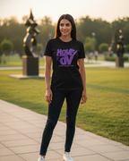 Woman wearing a black t-shirt with purple text in an outdoor setting