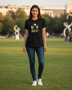 Woman wearing a black t-shirt with text and graphics on a grassy field