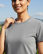 Woman wearing a gray t-shirt with a scenic background