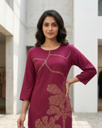 Woman wearing a maroon kurta with floral patterns in an outdoor setting