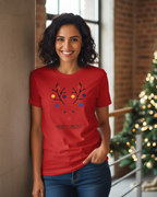 Woman wearing a red Christmas-themed t-shirt with a reindeer design, standing in front of a decorated Christmas tree.