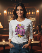 Woman wearing a white long-sleeve shirt with 'You Grow Girl' text in a bar setting