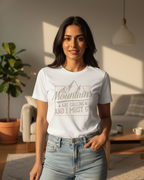 Woman wearing a white t-shirt with a mountain design and text in a living room.