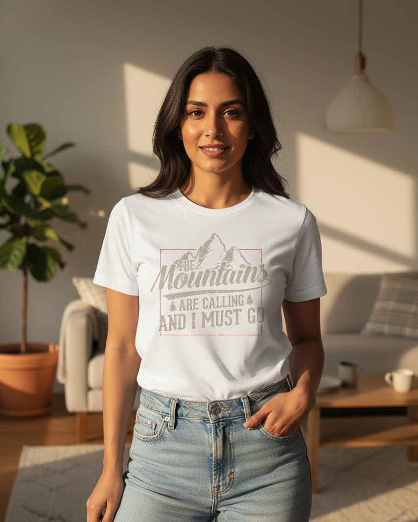 Woman wearing a white t-shirt with a mountain design and text in a living room.