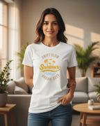 Woman wearing a white t-shirt with a summer-themed design in a living room.