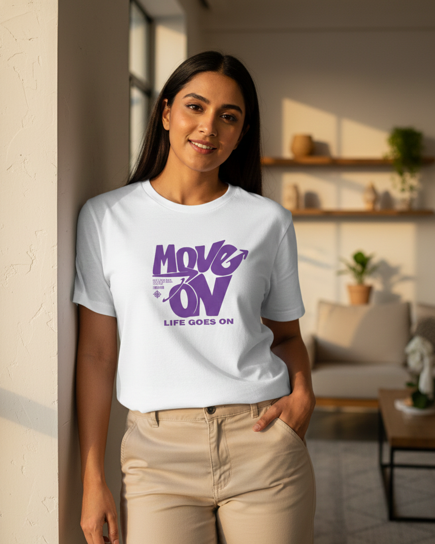 Woman wearing a white t-shirt with purple text in a living room setting