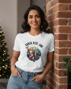Women wearing a 'Santa Kite Jam' t-shirt in front of a brick wall with lights.