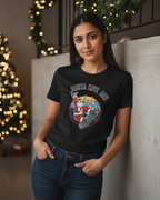 Women wearing a black t-shirt with a graphic design in front of a decorated Christmas tree.