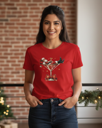 Women wearing a red t-shirt with a Christmas-themed design in front of a decorated Christmas tree.