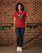 Women wearing a red t-shirt with a graphic design against a brick wall.