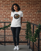 Women wearing a white t-shirt with a logo against a brick wall.