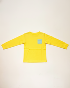 Yellow long-sleeve shirt with a small blue logo on a beige background