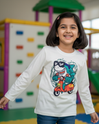 Young girl in a colorful indoor playground wearing a white shirt with a graphic design.