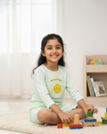 Young girl playing with colorful building blocks on a light-colored rug