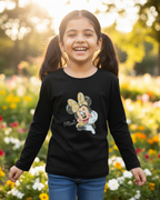 Young girl wearing a black long-sleeve shirt with a Minnie Mouse graphic, standing in a garden.