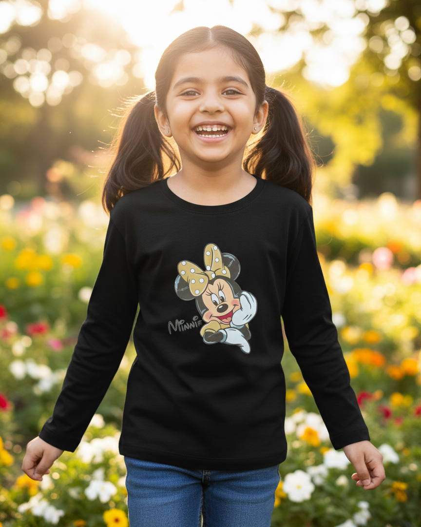 Young girl wearing a black long-sleeve shirt with a Minnie Mouse graphic, standing in a garden.