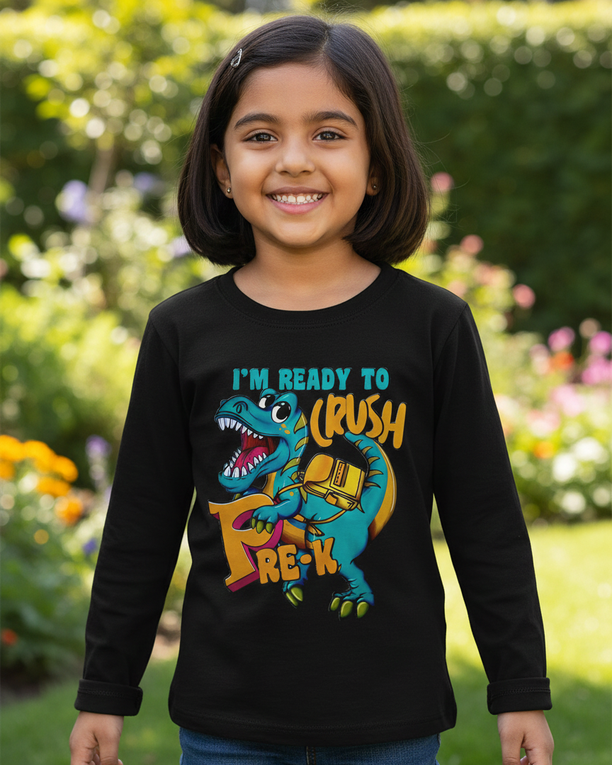 Young girl wearing a black long-sleeve shirt with a colorful dinosaur graphic and text, standing outdoors.