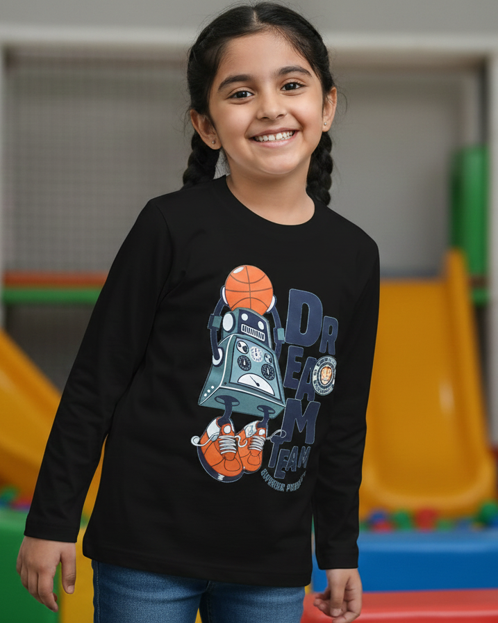 Young girl wearing a black long-sleeve shirt with a graphic design in an indoor playground.