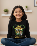 Young girl wearing a black sweatshirt with a colorful design, sitting on the floor in a room.