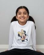 Young girl wearing a white sweatshirt with a Minnie Mouse design on a plain background