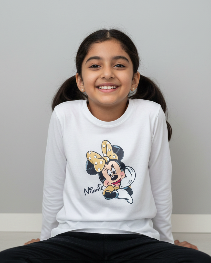 Young girl wearing a white sweatshirt with a Minnie Mouse design on a plain background