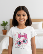 Young girl wearing a white t-shirt with a cartoon character design in a bedroom setting